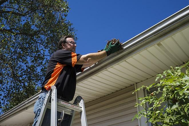 roofer fixing a sagging gutter on a building in Chatham